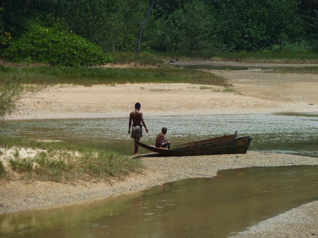 Jungs inspizieren ein kleines Boot in der Lagune.